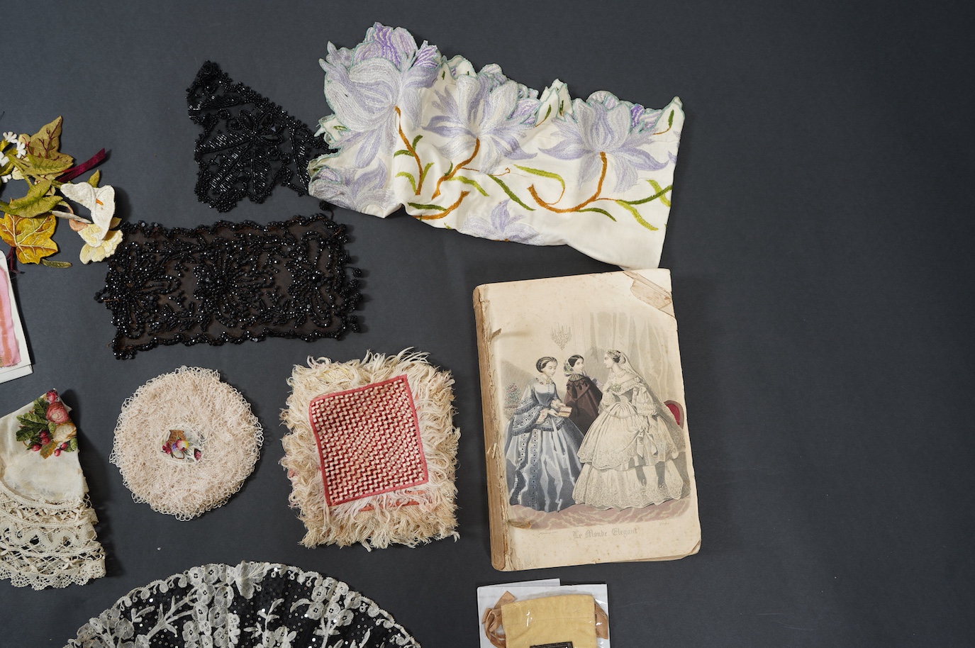 A French tortoiseshell, net, sequin and Honiton bobbin lace fan, with a collection of Jet appliques, a bead work fronter, embroidered mats and silk mats, an early Tiffany &Co poshette and embroidered appliqués and a Le M